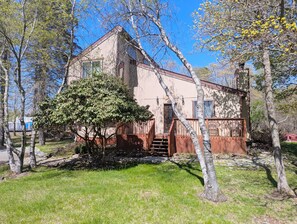 Un bâtiment à deux étages, doté d’un porche et d’un arbre devant.