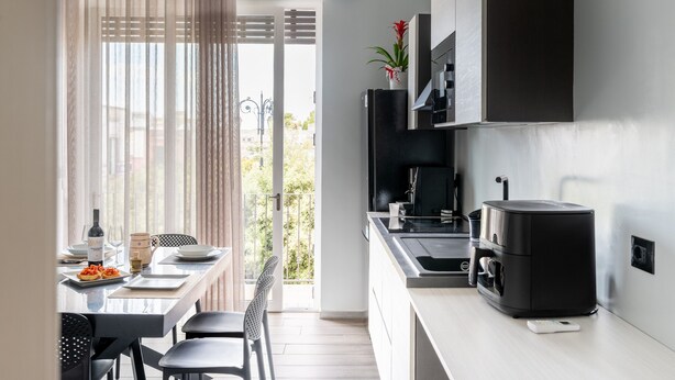 Une cuisine moderne avec un coin repas, une machine à café et une vue sur l’extérieur.