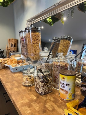 Een ontbijtbuffet met diverse soorten eten en een blik Chicarée Café.