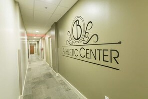 Un corridoio con un cartello appeso al muro che indica 'ATHLETIC CENTER'.