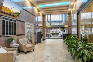 Un hall d’entrée avec un panneau indicateur, un espace détente et des plantes en pot.