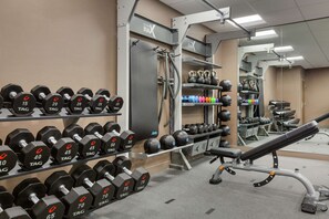 Ein Fitnessraum mit Gewichtsbänken, Kettlebells und Trainingsgeräten.