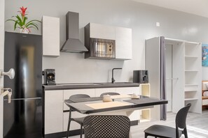 Una cucina moderna con forno a incasso, macchina del caffè e zona pranzo con tavolo e sedie.