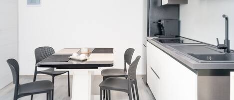 A modern kitchen with a built-in microwave, a coffee machine, and a stainless steel sink.