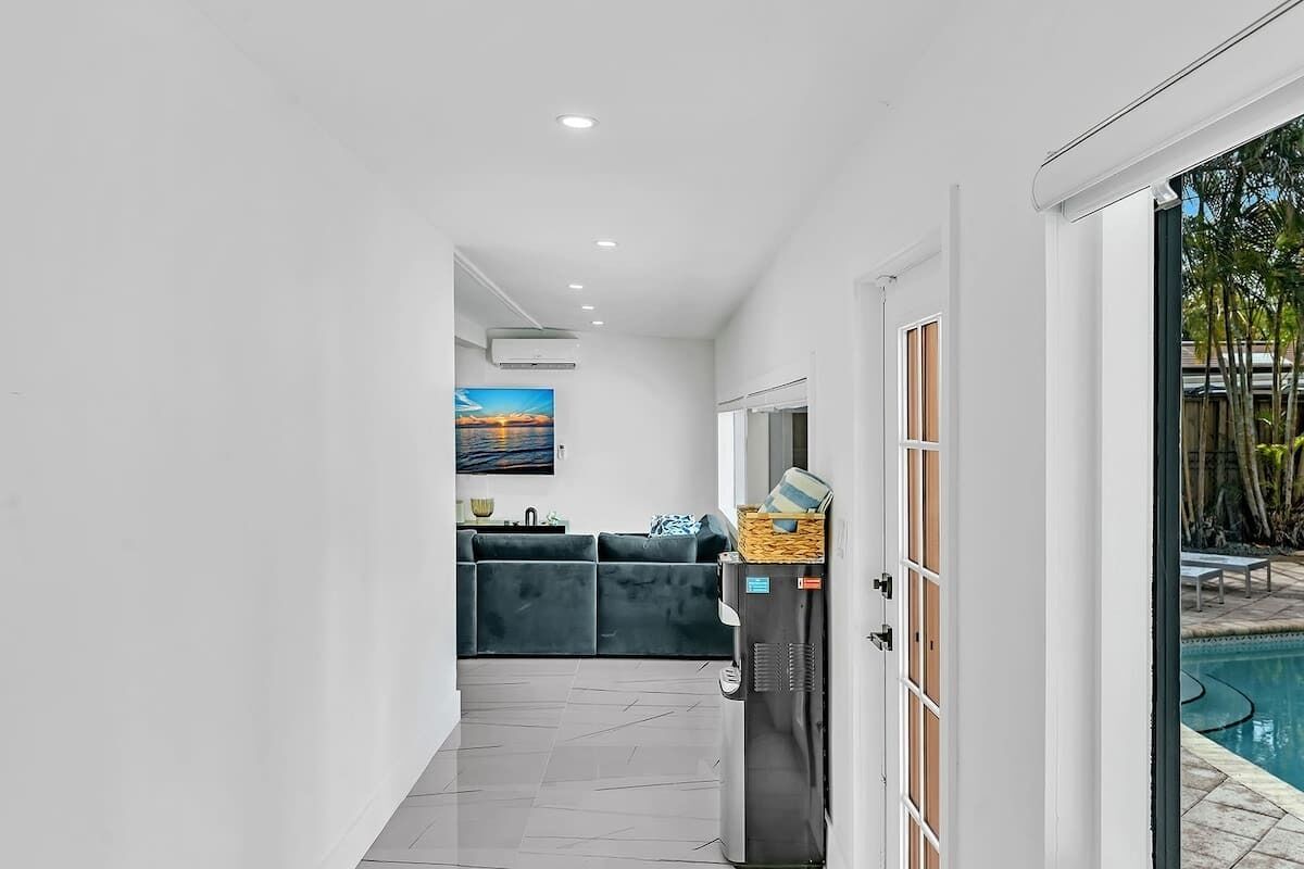 A modern interior with a pool, a refrigerator, and a sofa.