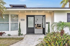 Ein modernes Haus mit einer schwarzen Tür, einer kleinen Veranda und einem Schild mit der Nummer 4024.