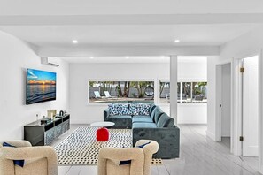 Ein modernes Wohnzimmer mit einer Couch, einem Couchtisch und einem Fernseher.
