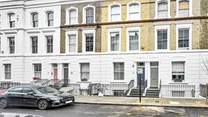 A row of white and yellow brick townhouses with numbered doors, a black car parked on the street, and a metal fence in front. - Chelsea Modern - Stylish Hideaway (London)