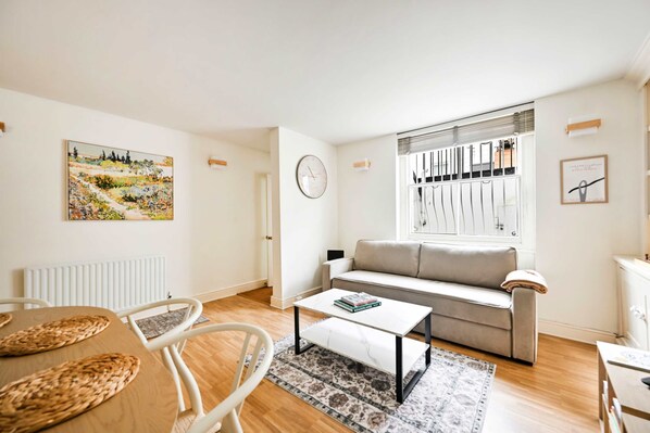 Ein Wohnzimmer mit Sofa, Couchtisch und einem Bild an der Wand.