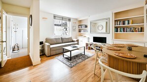 A modern living room with a sofa, coffee table, and bookshelf. - Chelsea Modern - Stylish Hideaway (London)