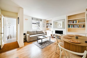 A modern living room with a sofa, coffee table, and bookshelf. - Chelsea Modern - Stylish Hideaway (London)