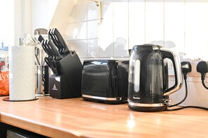 A kitchen counter with a coffee maker, knife set, and a bag of coffee. - Chelsea Loft - Stylish Sanctuary (London)