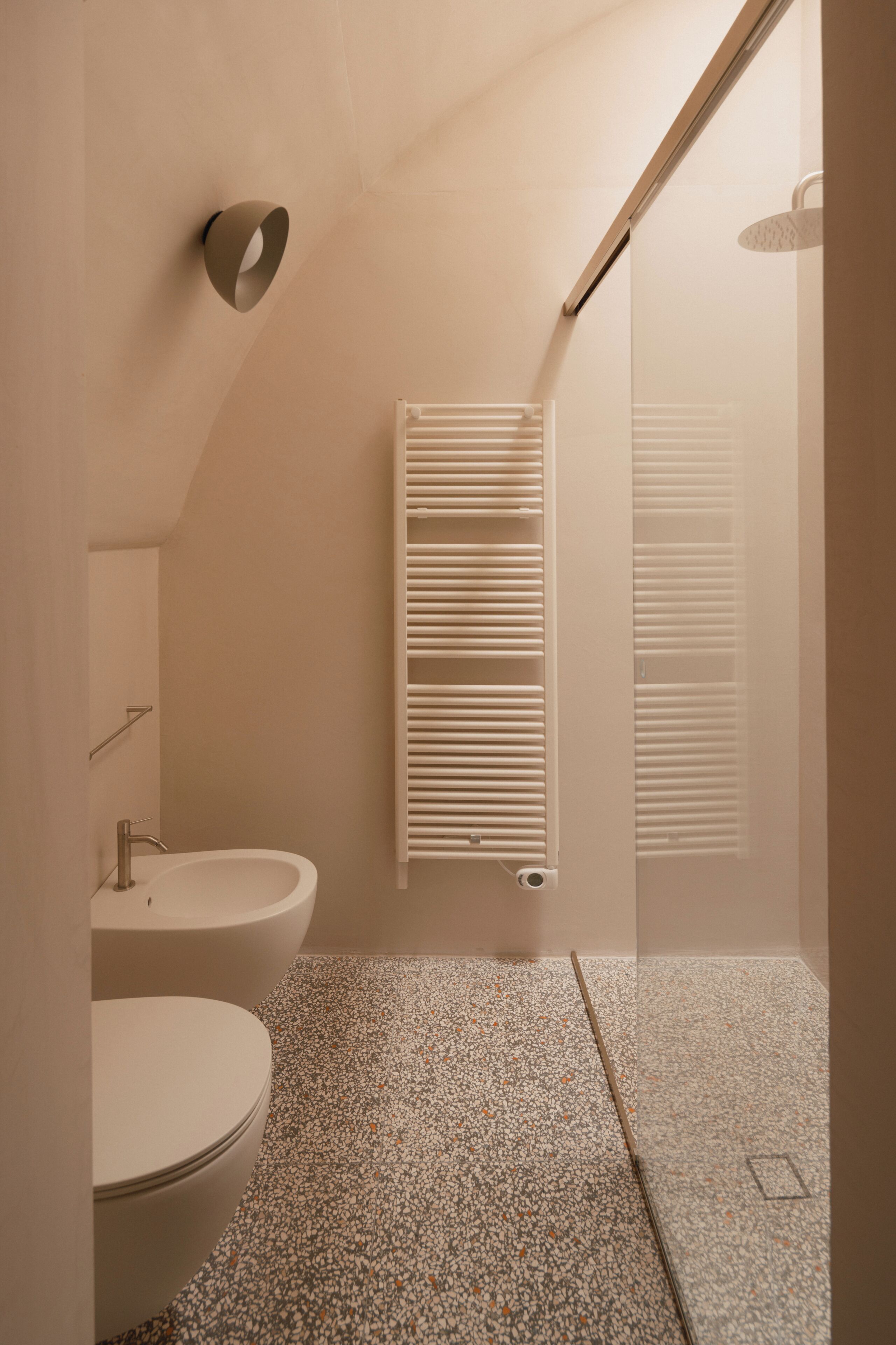 A bathroom with a toilet, sink, and shower.