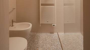 A bathroom with a toilet, sink, and shower.