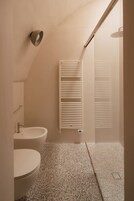 A bathroom with a toilet, sink, and shower.