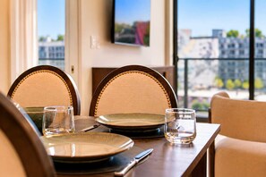 A dining table set with plates, glasses, and cutlery, with a city view through large windows. - Stylish Wynnwood Apartment with Resort Pool & Gym (Miami)