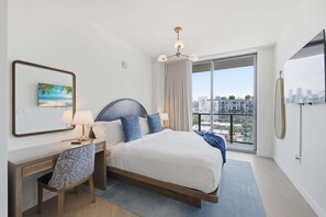 A modern hotel room with a bed, desk, chair, and large window with a city view. - Stylish Wynwood Apartment with Resort Pool and Gym (Miami)