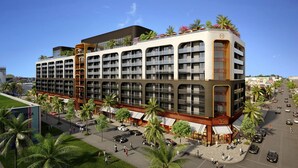 A multi-story hotel with balconies, a central courtyard, and palm trees.