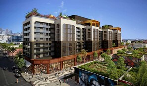 Un hôtel à plusieurs étages doté d’une architecture moderne, avec des balcons et une cour aménagée.