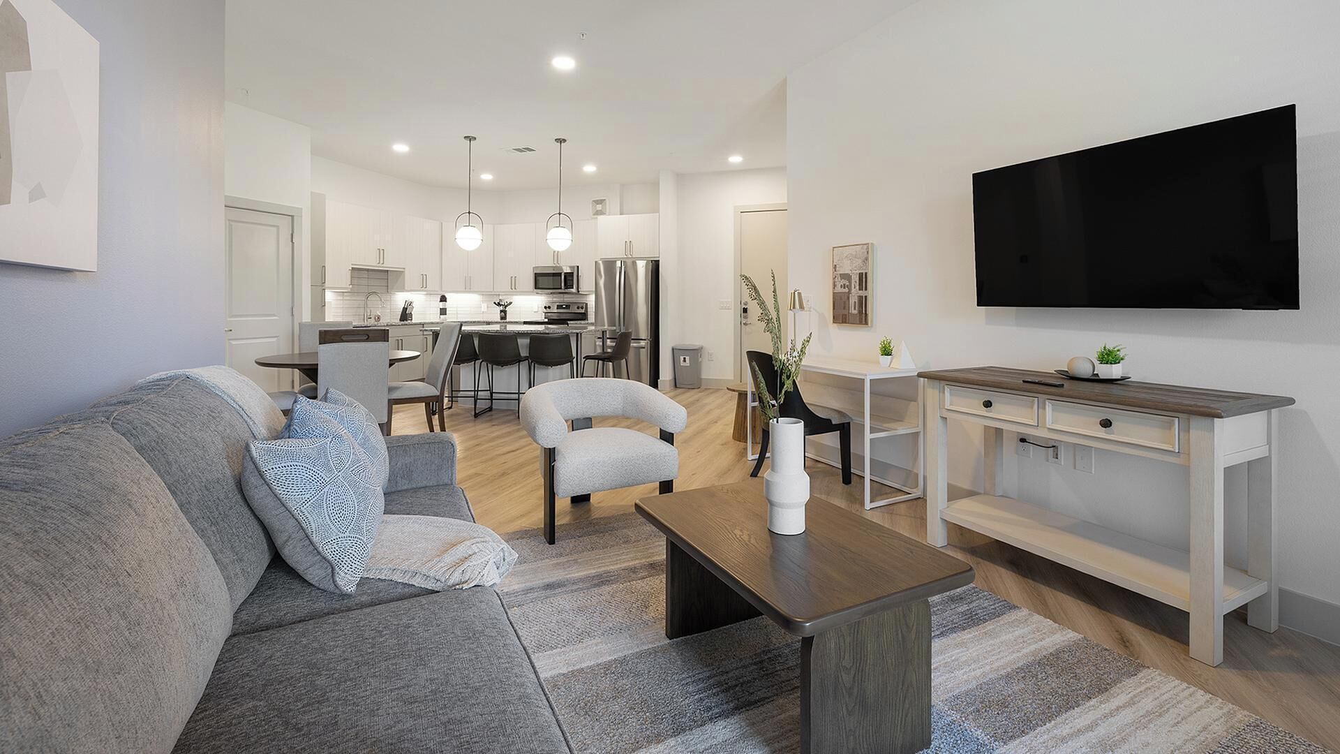 Una sala de estar moderna con un sofá, una mesa de centro y un televisor.