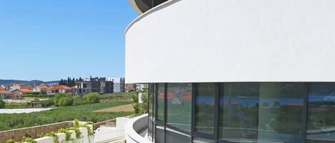 A modern building with curved balconies and large windows.