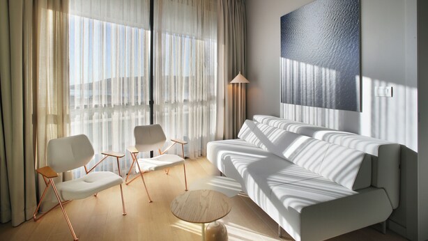 A modern living room with a sofa, chairs, a lamp, and a large abstract painting. - Trogir sky view suites (Trogir)