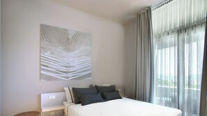 A modern bedroom with a large bed, a bedside table, a wall-mounted artwork, and a window with curtains. - Trogir sky view suites (Trogir)