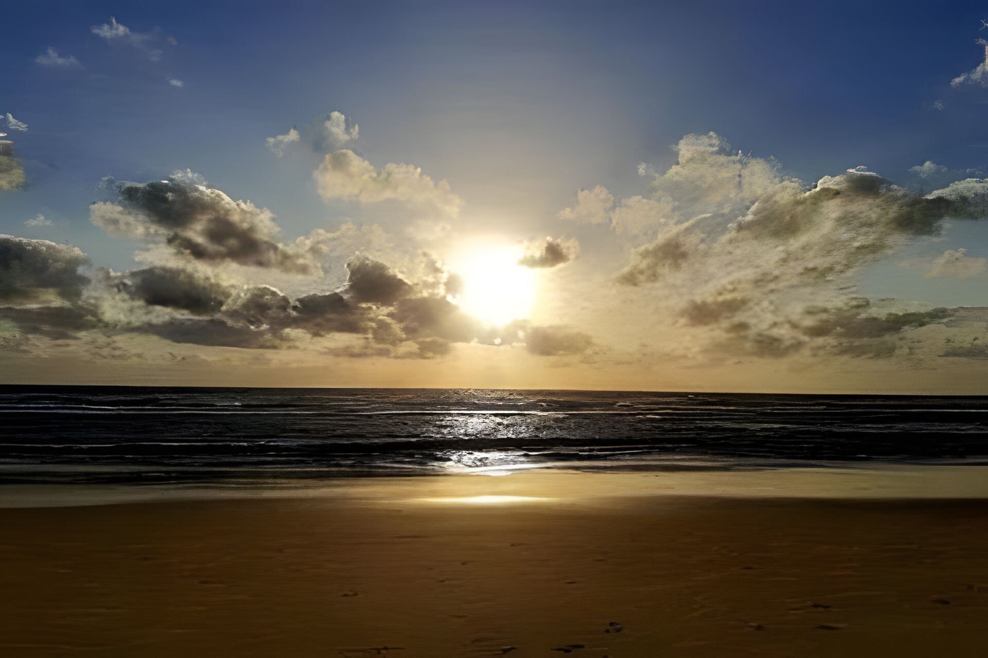 A beach with the sun setting over the ocean, creating a silhouette of clouds.