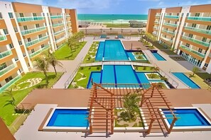 A resort with multiple swimming pools, a beach view, and a modern architectural design. - VG Fun Residence - Praia do Futuro (Fortaleza)