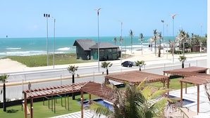 Un hotel sulla costa con vista sulla spiaggia, un edificio di piccole dimensioni e zone relax all'aperto.