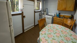Une petite cuisine équipée d’une cuisinière à gaz, d’un évier et d’une fenêtre.