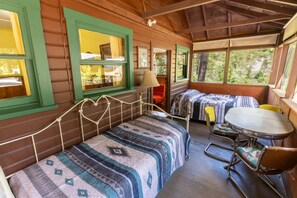 L’intérieur d’un chalet confortable, avec un lit, une petite table et une chaise.
