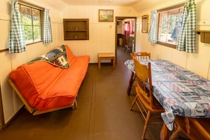 A cozy room with a sofa, a dining table, and a bench.