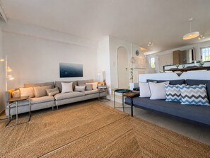 Una sala de estar moderna con un sofá, una mesa de centro y una alfombra.