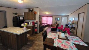 A compact living space with a kitchen, dining area, and living room. - 2-bedroom mobile home a minute off the Suncoast Parkway. Comfy and cozy! (Homosassa)