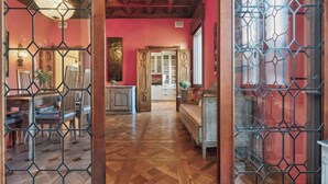 Una habitación con piso de madera, un comedor con sillas y una mesa, un sofá y una pared decorativa.