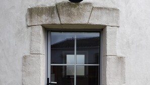 Une porte avec un panneau de verre, une poignée en métal et un objet circulaire placé au-dessus.