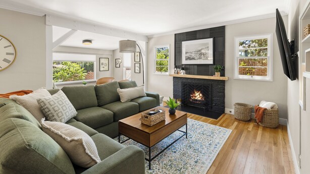 A living room with a sofa, a coffee table, a fireplace, and a television.