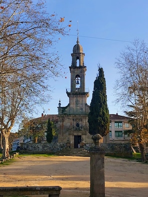 A historic building with a bell tower, a courtyard, and a statue. - YourHouse O Foxo apartment (Allariz)