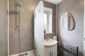 A modern bathroom with a shower, sink, mirror, and towel rack. - Spacious 4BR Home Sleeps 8 by Stay With Us (County Durham)