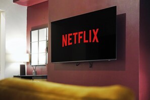 Televisão presa na parede exibindo o logotipo da Netflix.