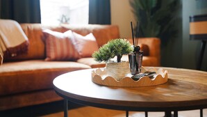 Una mesa redonda de madera con una pequeña planta en maceta y un candelabro.