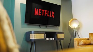 Un televisor montado en la pared con la palabra 'NETFLIX' en letras rojas.