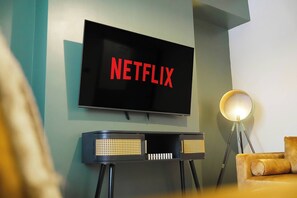 Un televisore fissato al muro con la scritta 'NETFLIX' in lettere rosse.