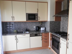 Eine Küche mit Mikrowelle, Toaster, Spüle, Geschirrspüler und Herd.