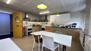A compact kitchen with a white table, two chairs, a stove, a microwave, and a sink. - Cosy Private Double in Westminster – Steps from Big Ben & Buckingham Palace (London)