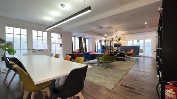 A spacious office with a large white table, colorful chairs, and a modern ceiling design. - Cosy Private Double in Westminster – Steps from Big Ben & Buckingham Palace (London)