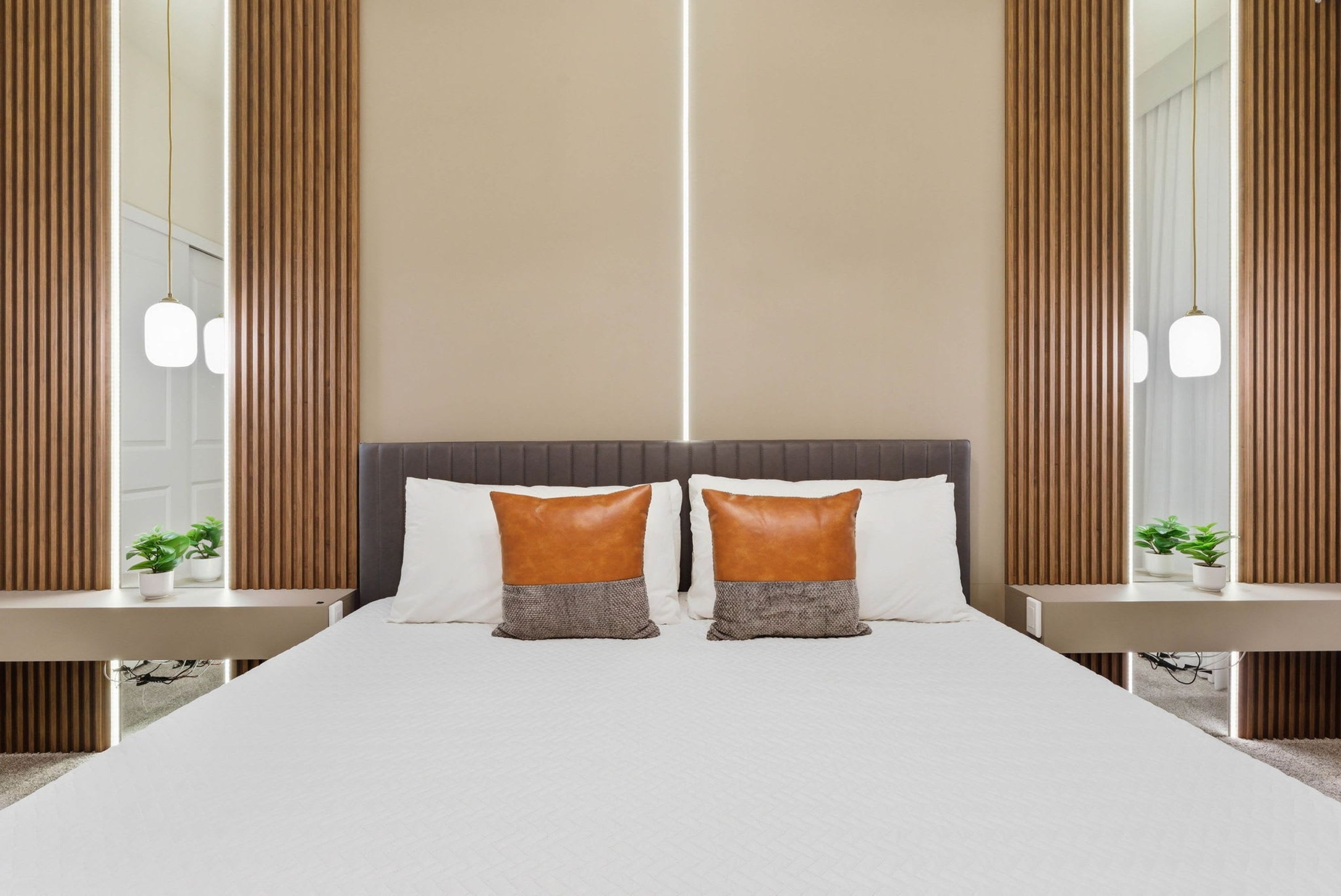 Een moderne hotelkamer met een groot bed, twee nachtkastjes en een spiegel.