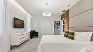 Una camera da letto moderna con un letto grande, una scrivania, una sedia e una scala.