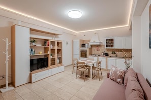 A modern living room with a TV, sofa, and dining area.